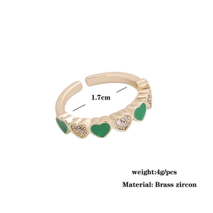 Macro detail of gold-plated heart ring with green enamel inlay and sparkling cubic zirconia