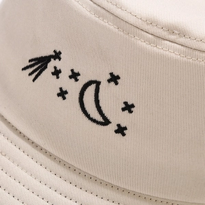 Beige cotton bucket hat with black moon and star embroidery for outdoor sun protection