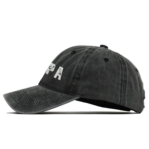 Dettaglio del ricamo PAPA su cappellino in cotone lavato nero con texture vintage