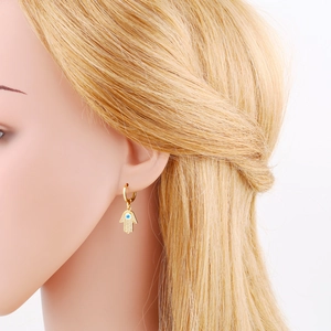 Vue détaillée des boucles d'oreilles Main de Fatma et Œil Bleu sur le mannequin