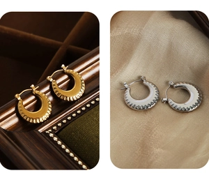 Macro view of gold and silver crescent earrings with textured geometric ripple surface