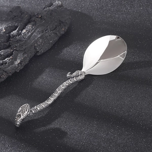 Macro detail of retro stainless steel spoon with creative snake shaped textured handle