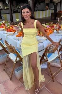 Detail of yellow bodycon dress featuring sheer mesh overlay and elegant tie straps