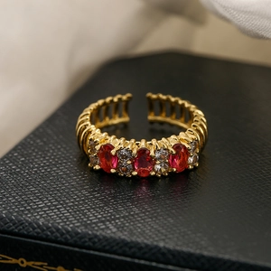 Vintage 18K gold plated open ring with red rubies and white zirconias in macro view
