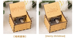 Detail view of vintage wooden hand-crank music boxes with themed engravings and metal movement