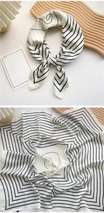 Detail of black and white geometric silk scarf tied on elegant wooden wave tray
