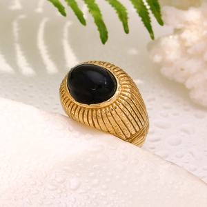 Close-up of vintage 18K gold plated ring featuring black onyx stone and ripple texture