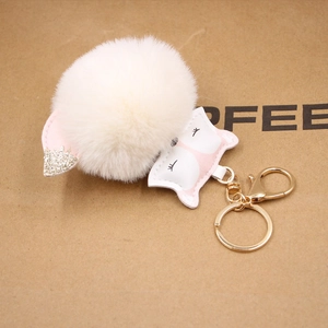 Detail of plush fox keychain with white fur pom pom, pink leather face and glittery ears