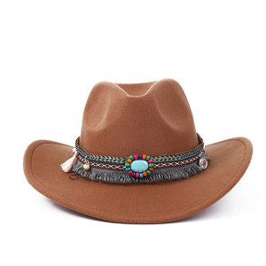 Détail d'un chapeau de cow-boy marron avec perles ethniques, turquoise et pompon à franges