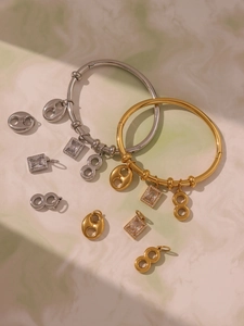 Detail of gold and silver stainless steel bangles with 5A cubic zirconia charms