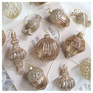 Champagne gold glitter Christmas ornaments with pine cone and candy shapes on fabric