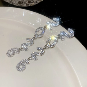 Macro shot of sparkling rhinestone number 2025 tassel earrings in silver finish
