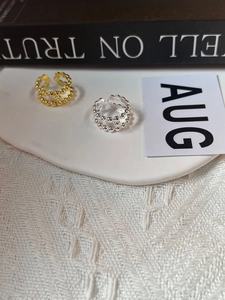 Dettaglio di eleganti anelli S925 in argento e oro a doppio strato con perline