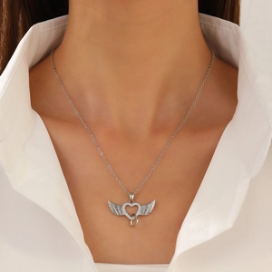 Macro shot of silver wing-heart pendant necklace with crystal inlay on a model neck