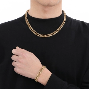 Golden stainless steel cuban link necklace and bracelet set shown on male model