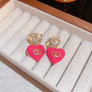 Macro detail of gold plated heart earrings with zircon studs on soft velvet tray