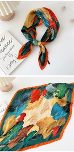 Macro detail of pleated silk scarf with colorful ginkgo leaf prints and fine accordion folds