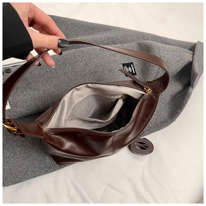 Detail view of large brown leather tote bag interior with herringbone lining and zip pocket
