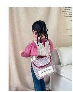 Detail of floral print crossbody bag with fabric patch and burgundy trim for kids