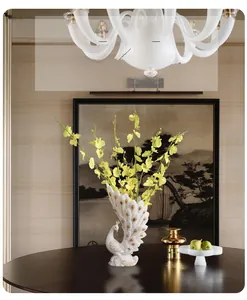 Detail view of a white peacock flower vase with golden accents and yellow flowers