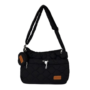 Détail d'un sac à bandoulière en nylon noir matelassé avec petit porte-monnaie rond