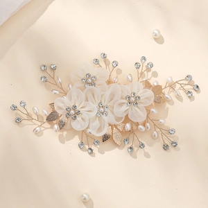 Detail of bridal hair clip with white chiffon flowers, pearls and golden leaves
