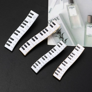Detail of four piano key hair clips with black and white enamel finish on metal base