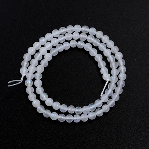 Macro shot of polished iridescent moonstone beads neatly arranged on a black background