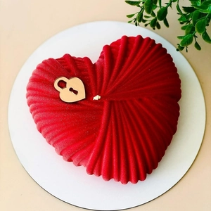 Gros plan d'un gâteau cœur rouge velours avec décoration de serrure dorée en métal