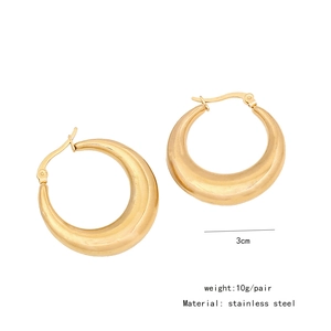 Detail shot of golden crescent earrings in stainless steel with 3cm size markings