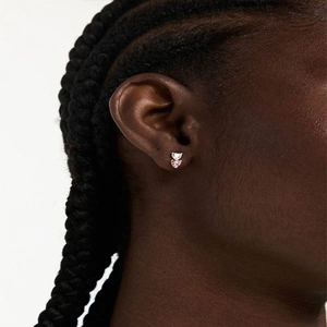 Close-up of heart-shaped pink and white zircon stud earrings on model's ear