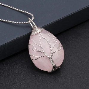 Macro shot of pink crystal Tree of Life pendant with intricate silver wire wrapping