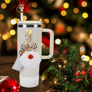 Close-up of Stanley 40oz cup with reindeer straw topper and white plush ball charm