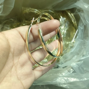 Golden 5mm wide curved hoop earrings in high-polished metal shown in hand close-up