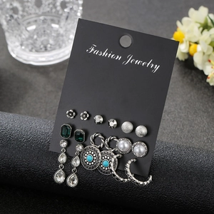 Detail of 9-pair silver earring set with pearls and crystals on a black fashion card