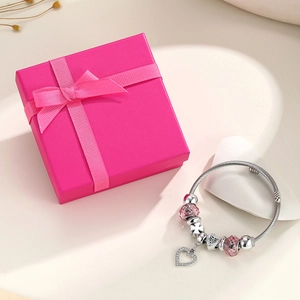 Detail of silver crown charm bracelet with pink crystal beads and heart pendant
