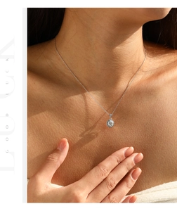 Detail of S925 sterling silver octagonal halo pendant necklace on neck with sunlight