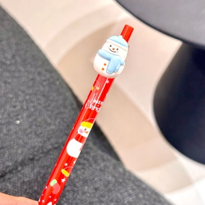 Macro view of Christmas ballpoint pen with 3D snowman accessory and Merry Christmas text
