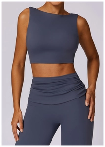Detail of high-waist yoga leggings with cross-waist design and racerback tank top in dark blue