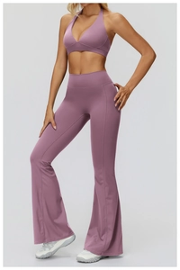Detail of purple halter yoga bra and flared leggings set with glossy athletic fabric