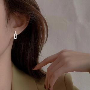 Orecchini geometrici rettangolari in argento minimalisti con primo piano della modella