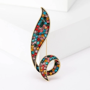 Retro gun black brooch with colorful crystals in leaf swirl design on white background