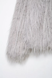 Detailed macro texture of grey faux fur coat showing soft plush fibers and silky shine