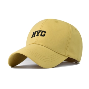 Detail shot of NYC embroidery on a yellow cotton baseball cap with ventilation eyelets