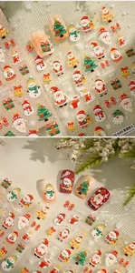 Dettaglio macro di adesivi 5D per unghie natalizie con motivi di Babbo Natale e pupazzo
