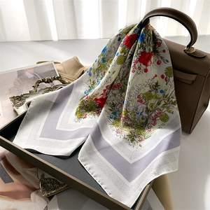 French floral silk square scarf with colorful prints draped over a stylish handbag