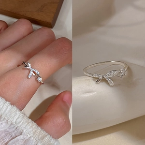 Macro shot of silver bow ring with sparkling zircons and a model wearing the piece