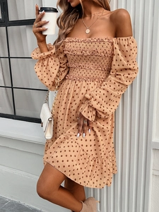 Detail of off-shoulder polka dot dress featuring elastic bodice and ruffle puff sleeves