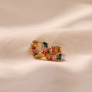 Detailed macro view of 18K gold huggie earrings set with rainbow rectangle zircons