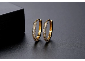 Macro view of gold hoop earrings with triple-row pavé-set crystals and polished finish